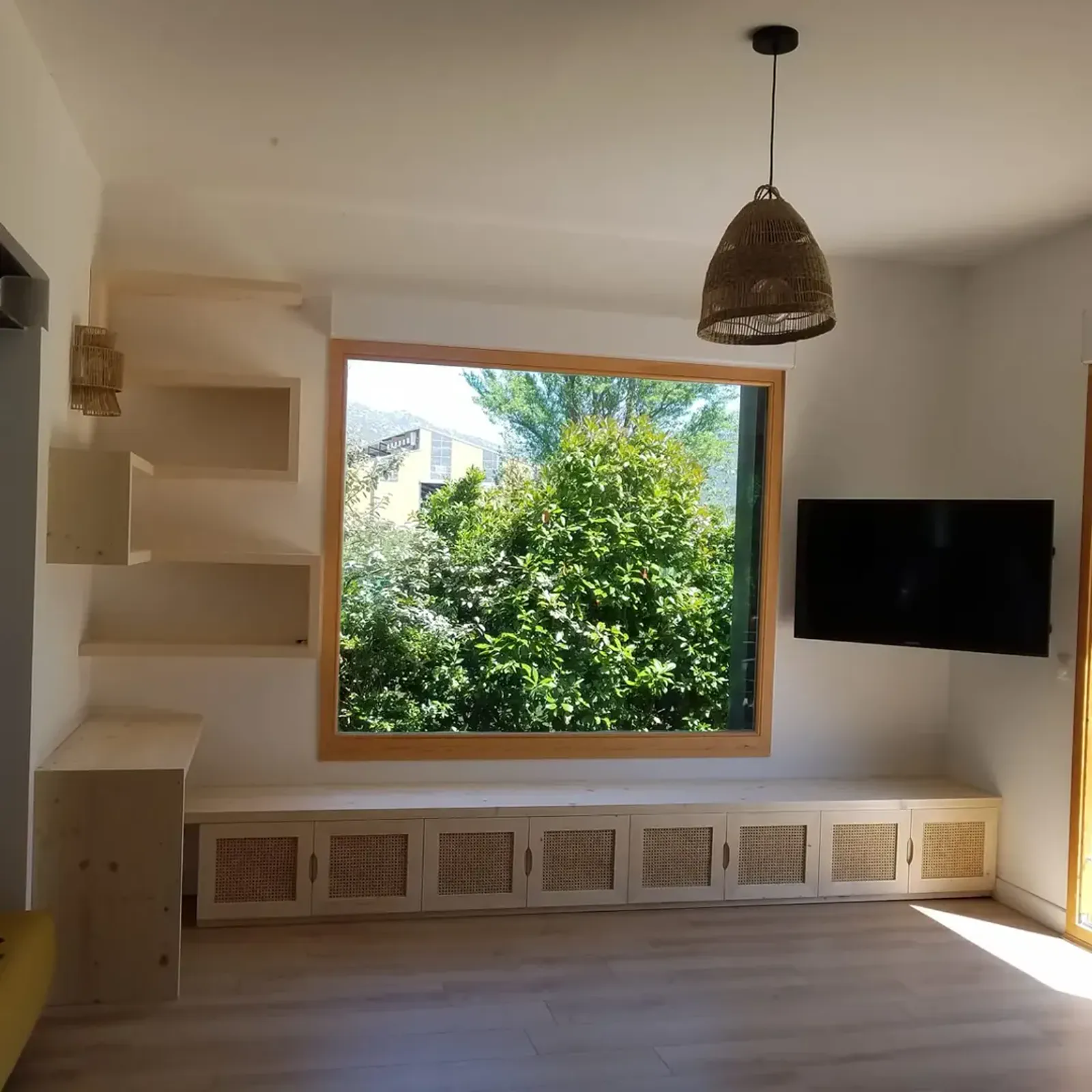 Banquette intégrée et rangements sur mesure sous une fenêtre