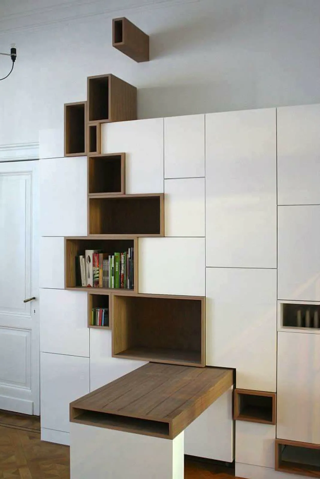 Bibliothèque et niches en bois intégrées dans un mur