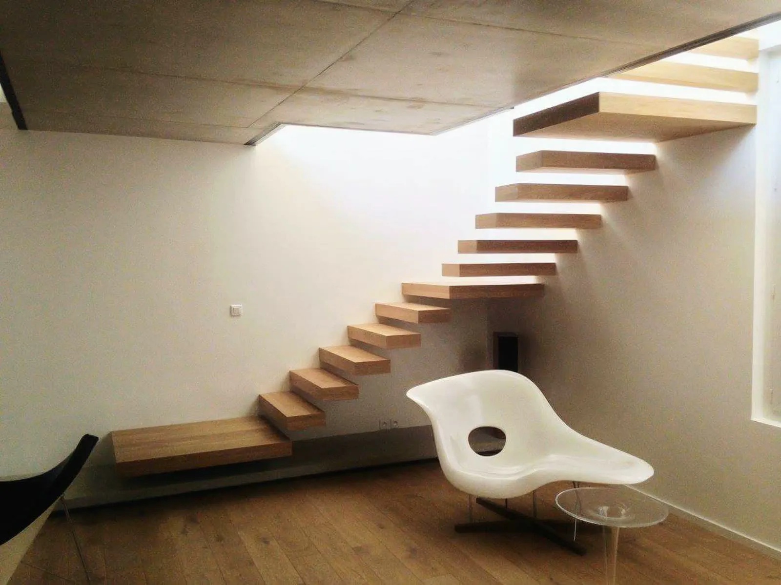 Escalier en bois à marches suspendues dans un intérieur clair